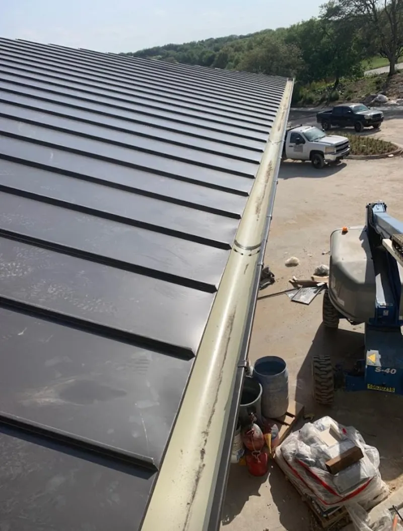 Standing seam panel and gutter detail on a metal roofing jobsite in Harwinton